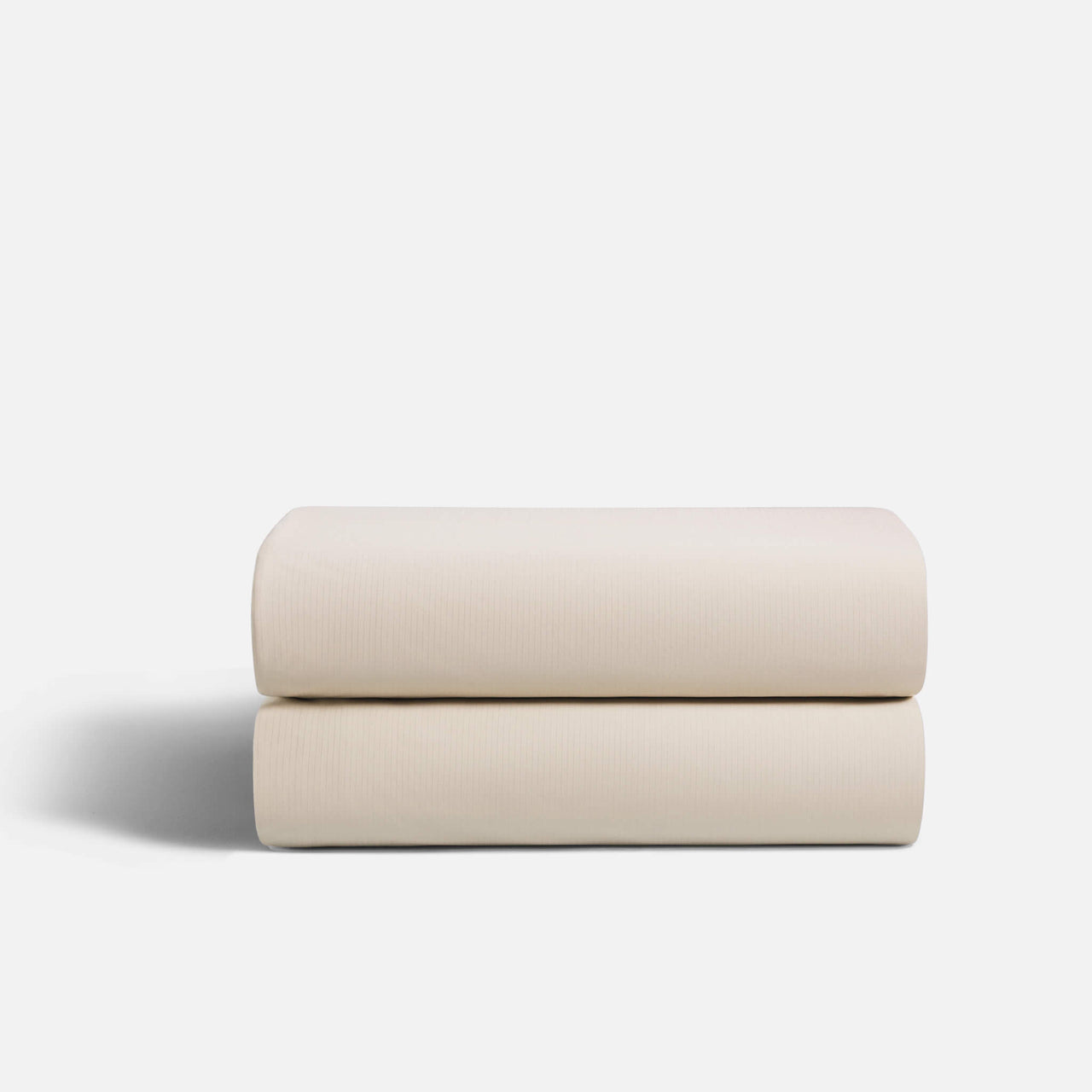 Cream fitted sheet with reinforced elastic corners stretched over a thick mattress, ensuring secure fit