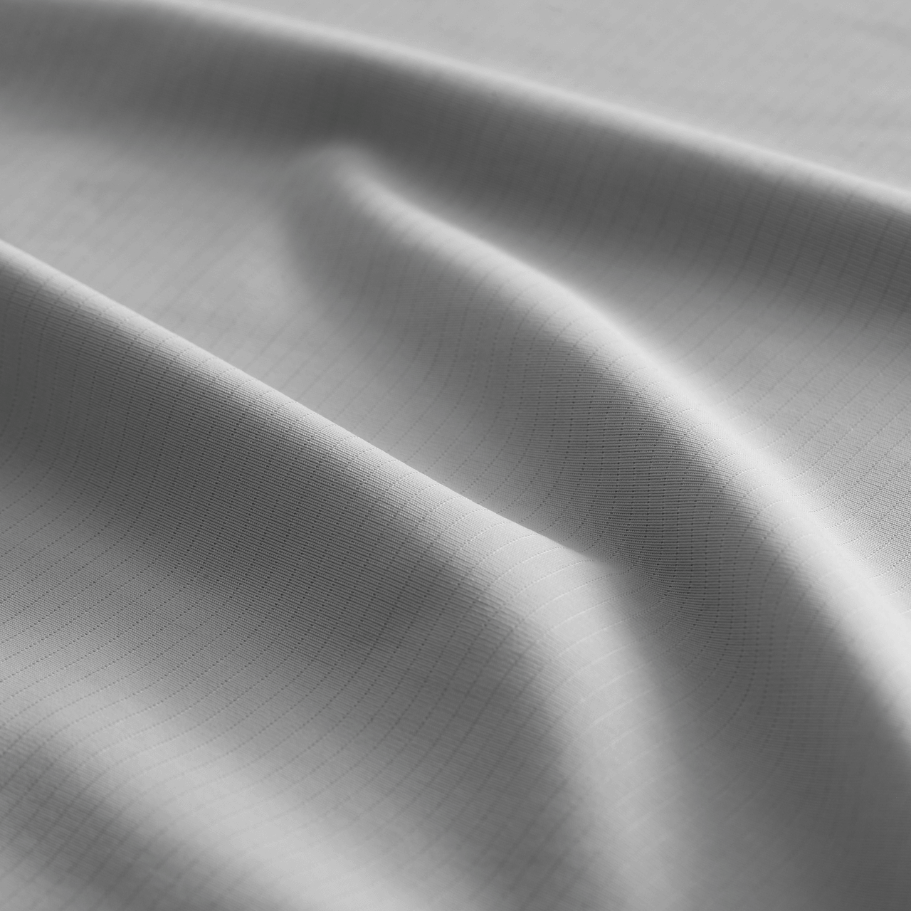 Gray CoolingCode™ bed sheets folded neatly, emphasizing breathability and comfort for all-night rest