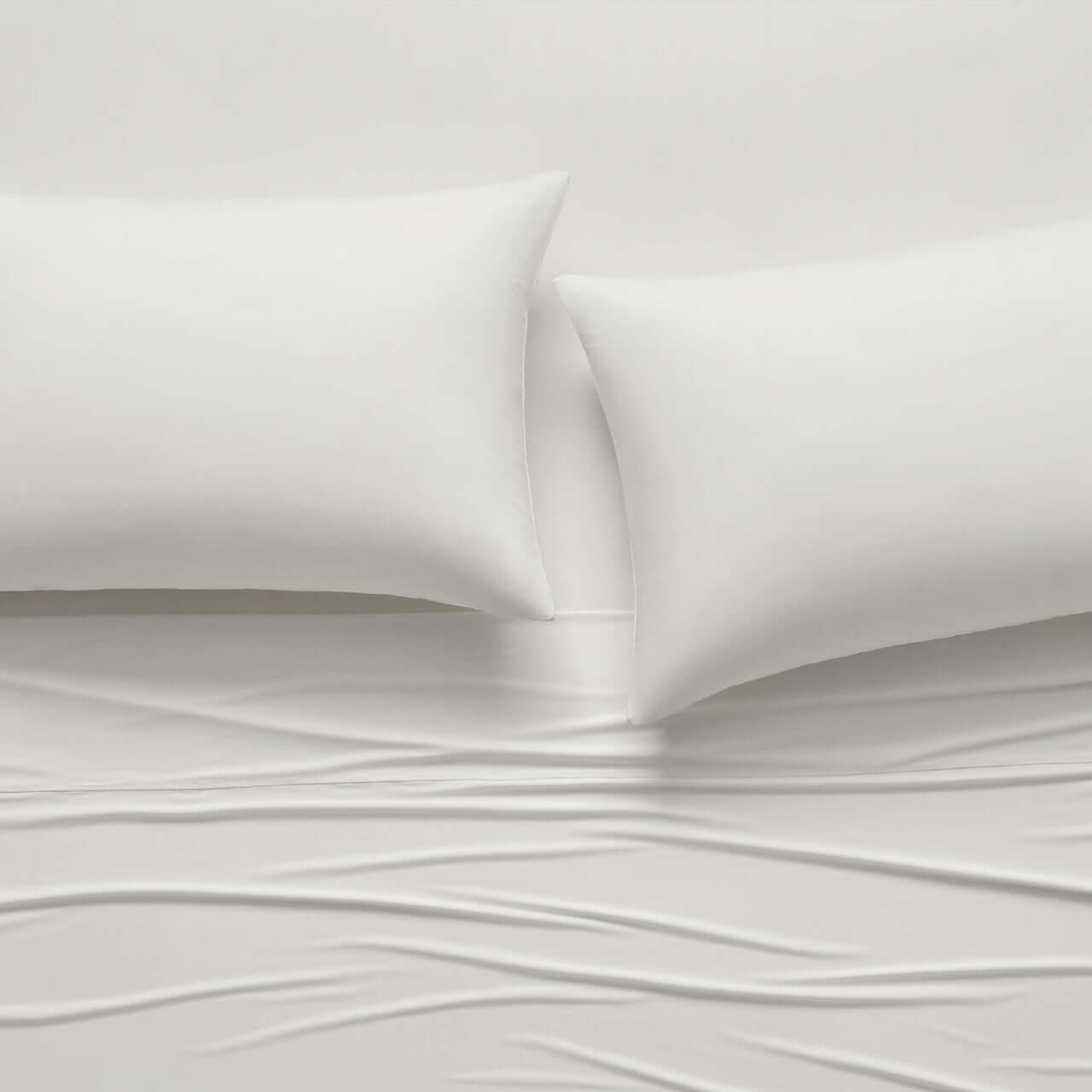 CoolingCode™ fitted sheet bundle featuring two white pillowcases on a cloud-like bed surface.